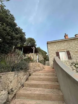 a set of stairs next to a brick building at Appartement au cœur d’un village in Foce