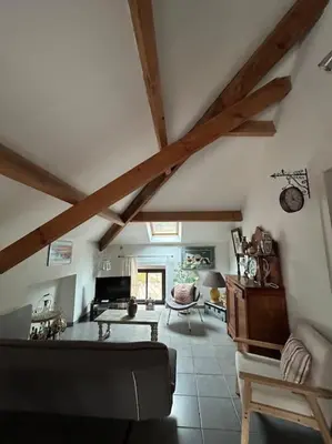 a living room with a ceiling with wooden beams at Appartement au cœur d’un village in Foce