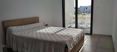 a bedroom with a bed and a balcony at Grand T2 neuf classé 3 étoiles in Porticcio