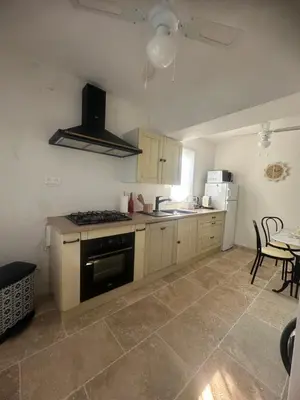 a kitchen with a stove top oven next to a table at casa in Palasca