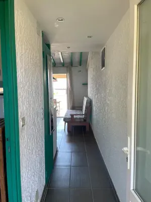 a hallway with a couch and a chair in a room at RESIDENCE LA PLAGE Pieds dans l'eau Belle Vue mer in Linguizzetta