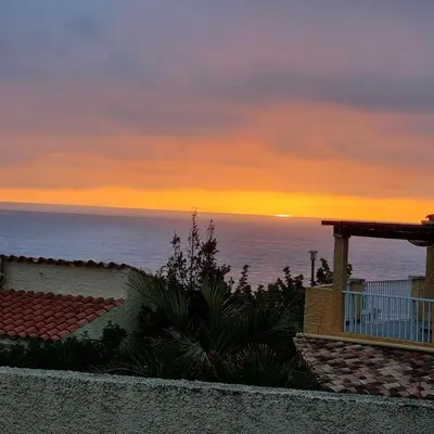 a sunset over the ocean from a house at RESIDENCE LA PLAGE Pieds dans l'eau Belle Vue mer in Linguizzetta
