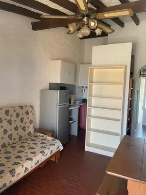 a living room with a couch and a refrigerator at RESIDENCE LA PLAGE Pieds dans l'eau Belle Vue mer in Linguizzetta