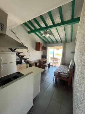 a kitchen with a couch and a table in it at RESIDENCE LA PLAGE Pieds dans l'eau Belle Vue mer in Linguizzetta