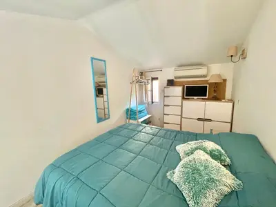 a bedroom with a blue bed with pillows on it at Villa Hameaux du soleil in Porticcio