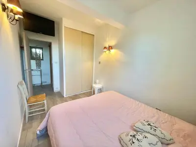 a bedroom with a pink bed with pillows on it at Villa Hameaux du soleil in Porticcio