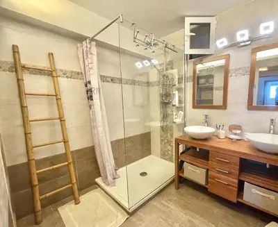 a bathroom with a glass shower and a sink at Villa Hameaux du soleil in Porticcio
