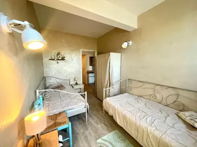 a small bedroom with a bed and a table at Villa Hameaux du soleil in Porticcio