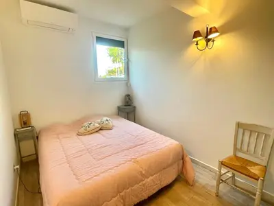 a bedroom with a bed and a window at Villa Hameaux du soleil in Porticcio