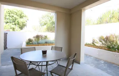 a dining room with a table and chairs and two large windows at Residence Catherine in Calvi