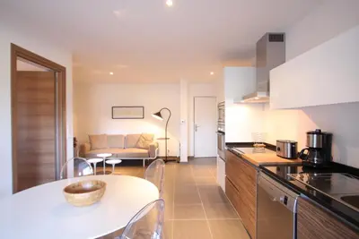 a kitchen and living room with a table and a couch at Residence Catherine in Calvi
