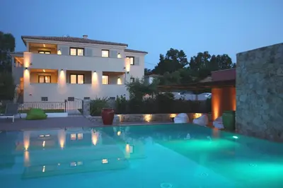 a villa with a swimming pool in front of a house at Residence Catherine in Calvi