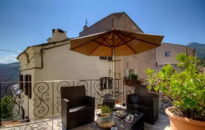 a balcony with an umbrella and a table and chairs at A Stella in Borgo