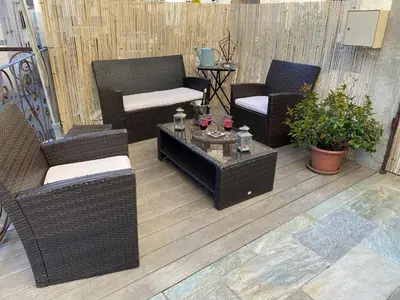 a patio with wicker chairs and a coffee table at A Stella in Borgo