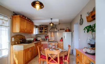 a kitchen with a small table and a white refrigerator at A Stella in Borgo