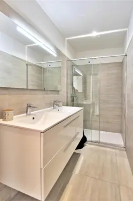 a bathroom with a white sink and a shower at Villa PIETRA 300m de la plage de Favone Piscine privée chauffée in Conca