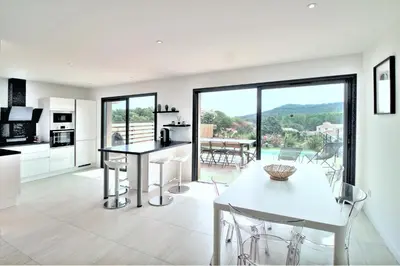 a kitchen and dining room with a table and chairs at Villa PIETRA 300m de la plage de Favone Piscine privée chauffée in Conca