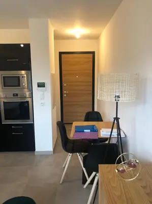 a living room with a table and a kitchen with a stove at T1 de standing avec vue in Corte