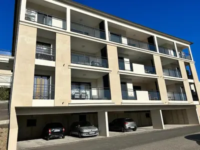 an apartment building with cars parked in front of it at T1 de standing avec vue in Corte