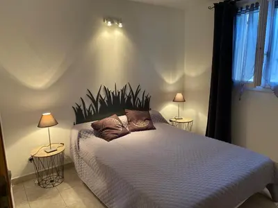 a bedroom with a large bed with two lamps at Appartement T2 Olmeto in Olmeto
