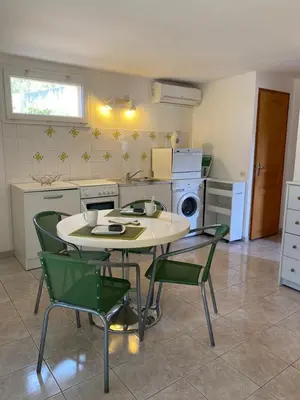 a kitchen with a table and chairs in a kitchen at Appartement T2 Olmeto in Olmeto