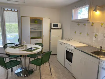 a kitchen with a table and a table and chairs at Appartement T2 Olmeto in Olmeto