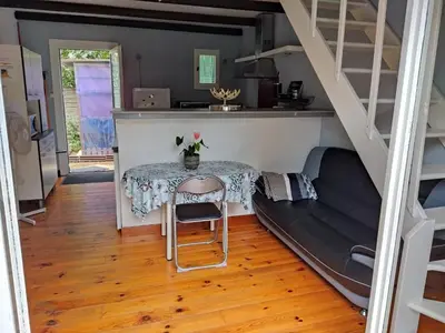 a living room with a table and a couch at Agréable villa 100 m de la plage in Poggio-Mezzana