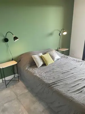 a bedroom with a bed with two lamps on it at Grand Studio moderne tout confort in Porto-Vecchio