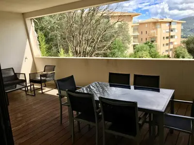 a patio with a table and chairs on a balcony at Grand Studio moderne tout confort in Porto-Vecchio