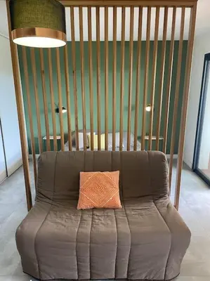 a brown couch with a pillow on top of it at Grand Studio moderne tout confort in Porto-Vecchio