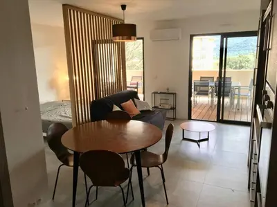 a living room with a table and a couch at Grand Studio moderne tout confort in Porto-Vecchio