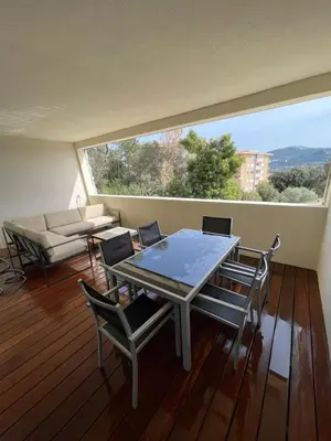 a table and chairs in a room with a large window at Grand Studio moderne tout confort in Porto-Vecchio