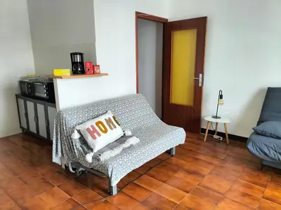 a living room with a couch and a chair at Studio face mer Porticcio, proche aéroport Ajaccio in Porticcio