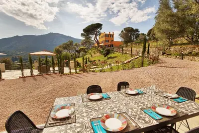 a table with plates on it on a patio at Le Domaine Saint François Le Moulin 1 in Ajaccio
