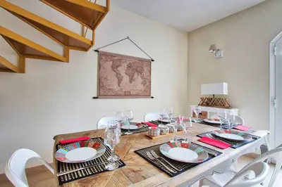 a dining room with a wooden table with white chairs at Le Domaine Saint François Le Moulin 1 in Ajaccio