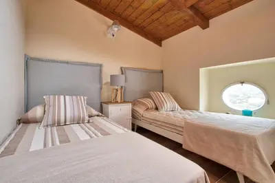 a bedroom with two beds and a window at Le Domaine Saint François Le Moulin 1 in Ajaccio