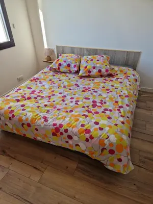 a bed with a colorful comforter and two pillows at A LIVIA Peri Ajaccio in Peri