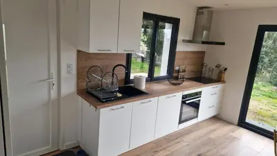 a kitchen with white cabinets and a window at A LIVIA Peri Ajaccio in Peri