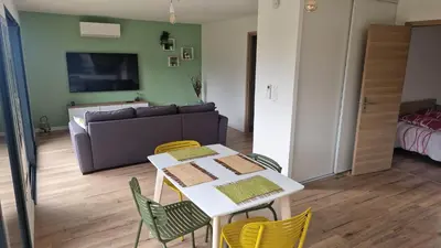 a living room with a table and chairs and a couch at A LIVIA Peri Ajaccio in Peri