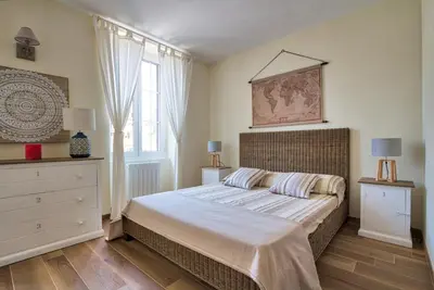 a bedroom with a bed and a dresser and a window at Le Domaine Saint François Le Moulin 2 in Ajaccio