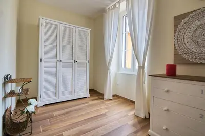 a bedroom with a white closet and a window at Le Domaine Saint François Le Moulin 2 in Ajaccio