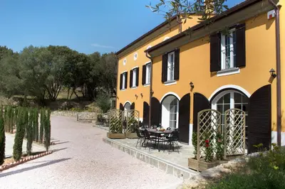 a yellow building with a table in front of it at Le Domaine Saint François Le Moulin 2 in Ajaccio