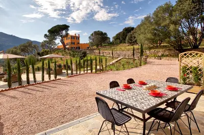 a table with bowls and plates on it on a patio at Le Domaine Saint François Le Moulin 2 in Ajaccio