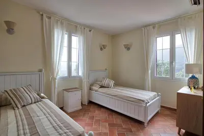 a bedroom with two beds and two windows at Le Domaine Saint François La Tour 1 in Ajaccio