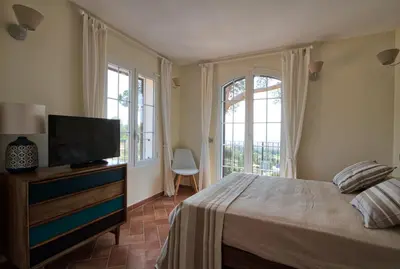 a bedroom with a bed and a flat screen tv at Le Domaine Saint François la Tour 2 in Ajaccio