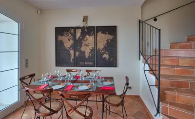 a dining room with a table with chairs and a map at Le Domaine Saint François la Tour 2 in Ajaccio