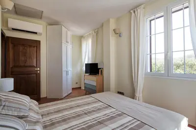 a bedroom with a large bed and a window at Le Domaine Saint François la Tour 2 in Ajaccio