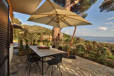 a table and chairs with an umbrella on a patio at Le Domaine Saint François la Tour 2 in Ajaccio