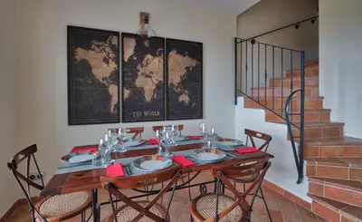 a dining room with a table with chairs and a map at Le Domaine Saint François la Tour 2 in Ajaccio