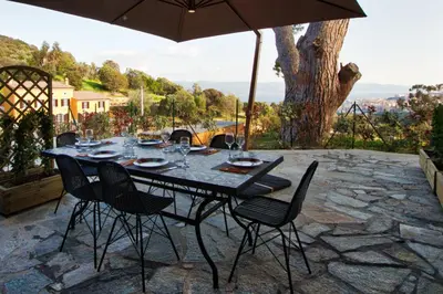 a table with chairs and an umbrella on a patio at Le Domaine Saint François La Tour 3 in Ajaccio